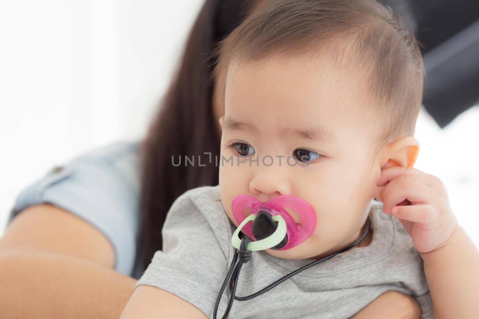 Closeup portrait of asian newborn, happiness face little baby girl with innocent, eyes of infant with feeling positive and cheerful, health and care, childcare and cozy.