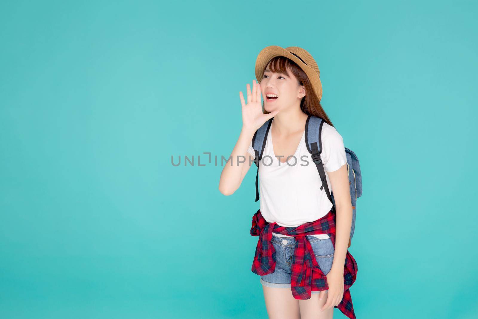 Beautiful young asian woman shouting sound loud with mouth for announce something in vacation travel with excited isolated on blue background, tourist asia girl journey in summer concept.