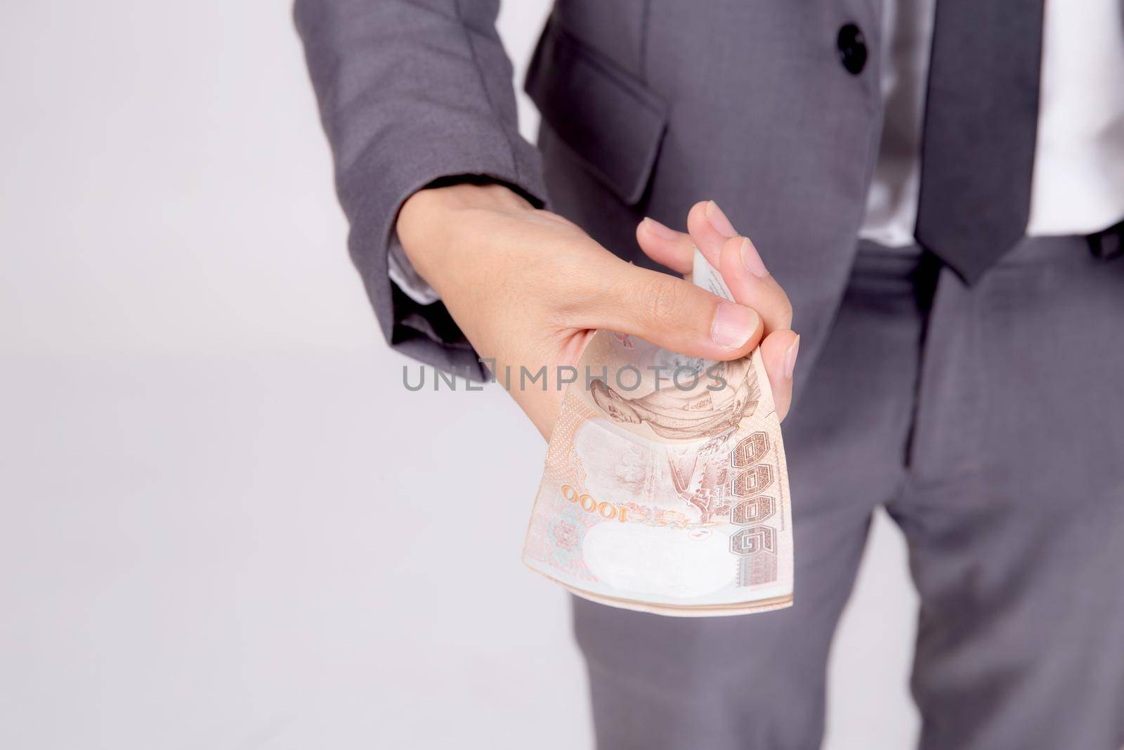 Hand of business man giving money isolated on white background, finance and cash, businessman holding banknotes Thai, deposit and loans, profit investment and bonus and success, currency and exchange.