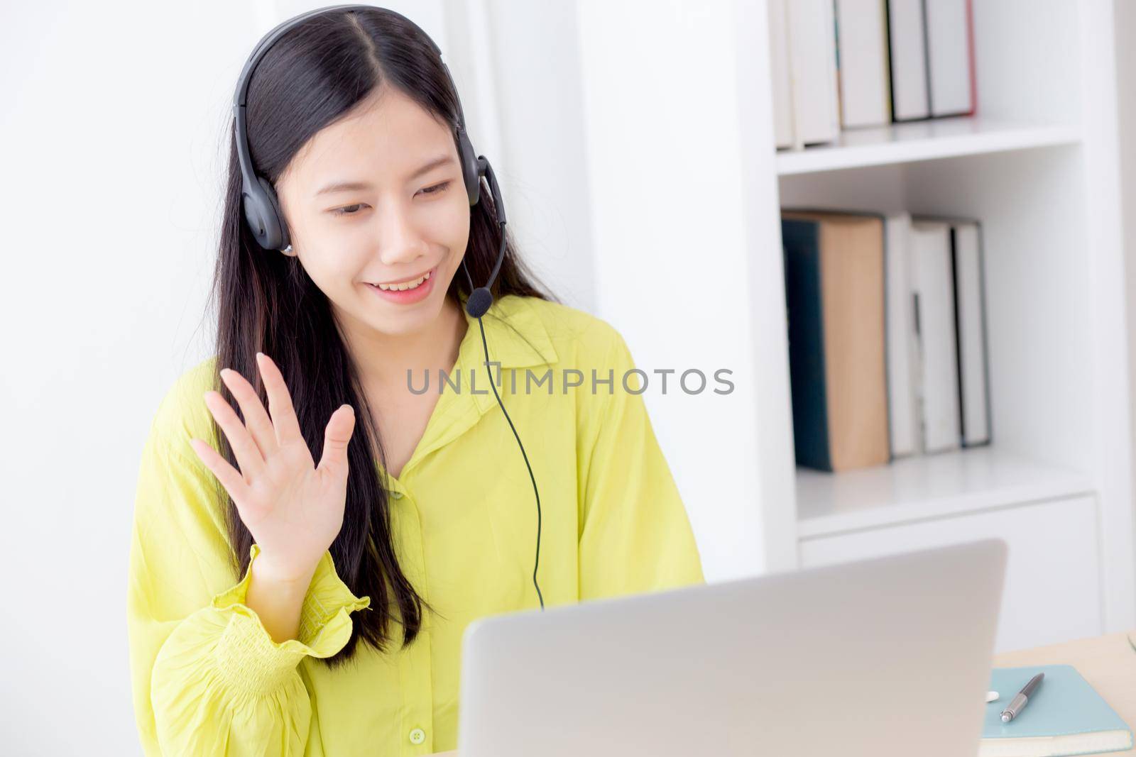 Young asian business woman using laptop computer for video conference online with social distancing, businesswoman working with video call, new normal, communication and work from home concept.