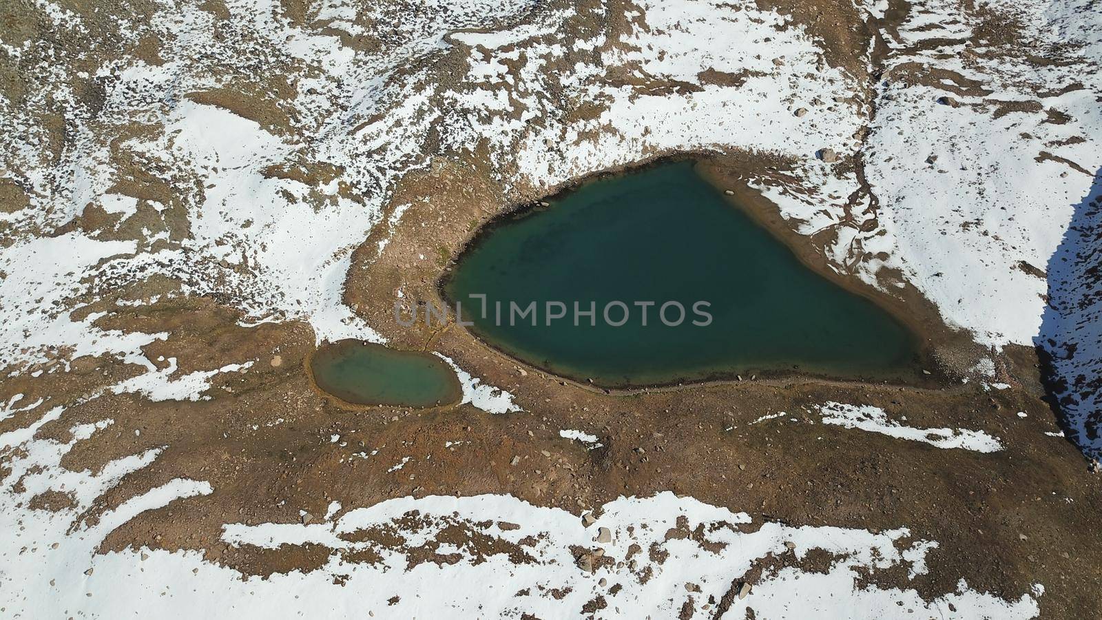 Snow-capped mountains and a lake. View from top. by Passcal