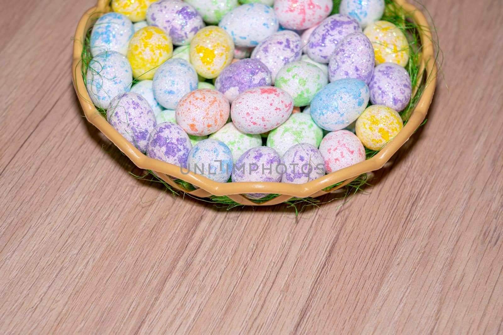 easter colorful eggs in a nest close up on a wooden background. High quality photo