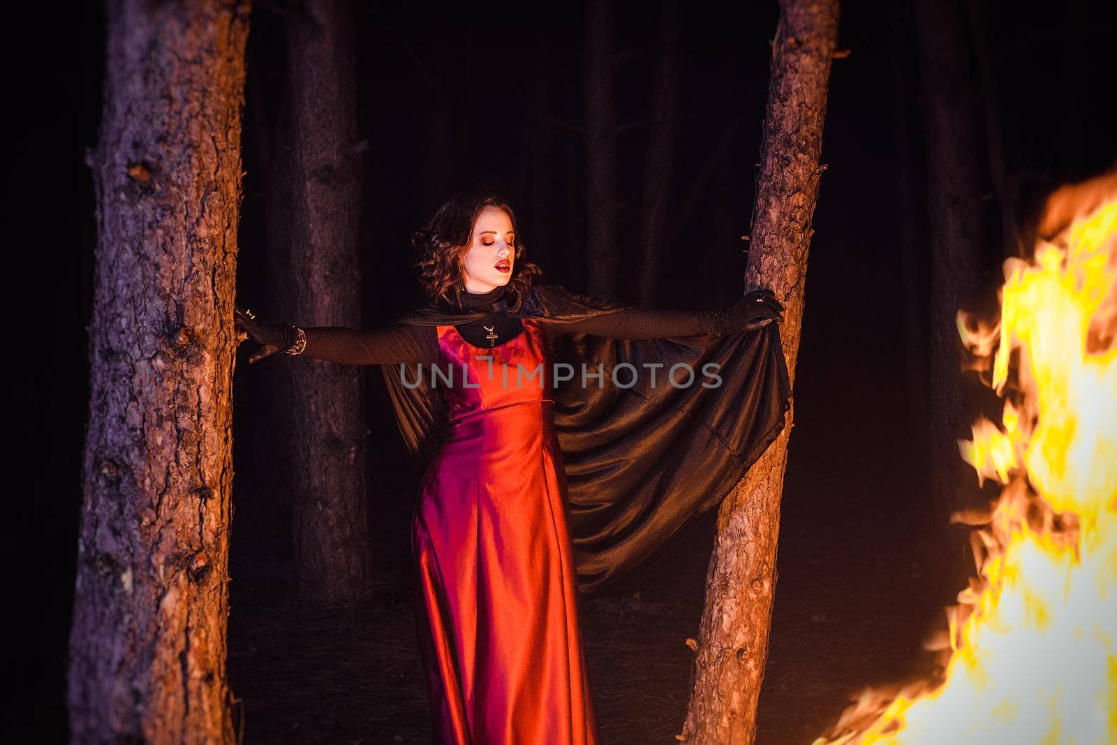 girl alone at night in the forest brews a potion and wonders for marriage, surrounded by candles and smoke