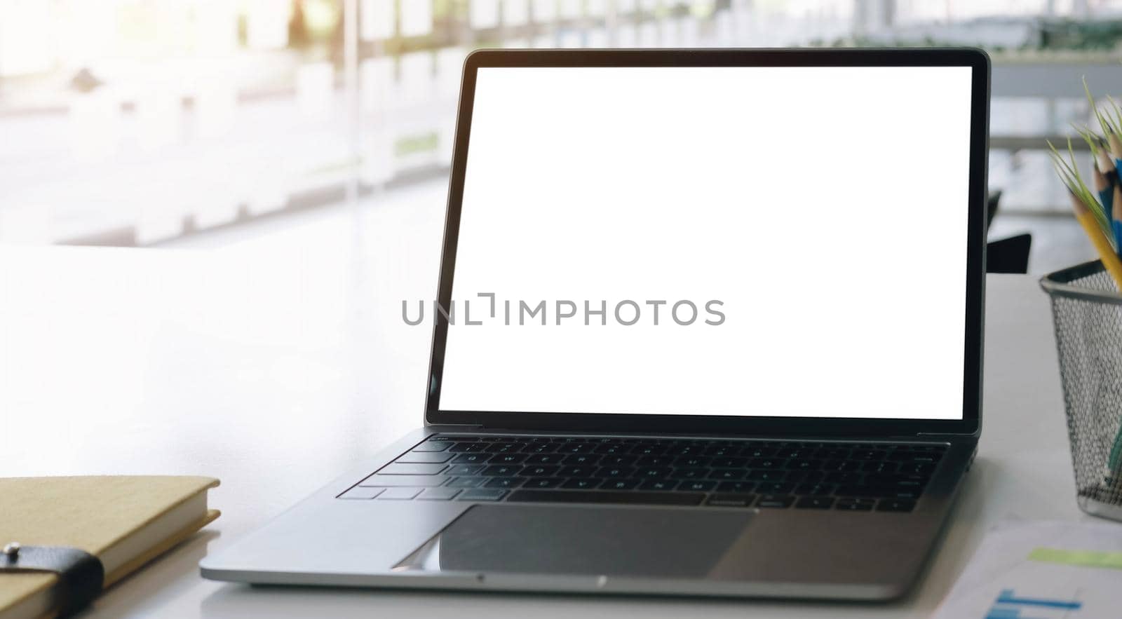 Blank screen Laptop computer and poster workspace background in modern office.