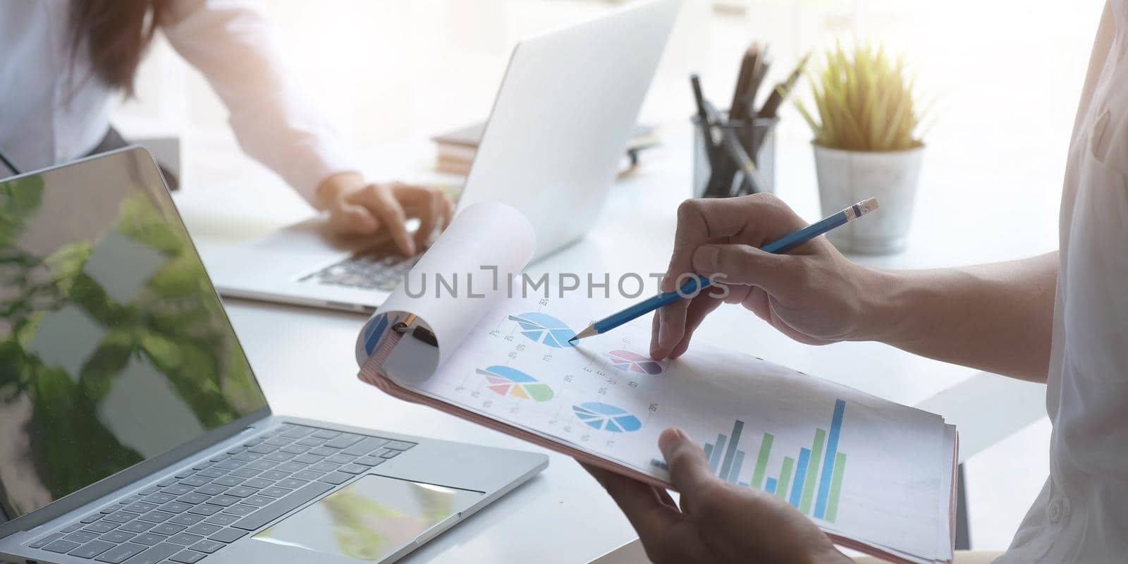 Team Businessman holding pencil working on financial report and business woman using the laptop in office. by wichayada