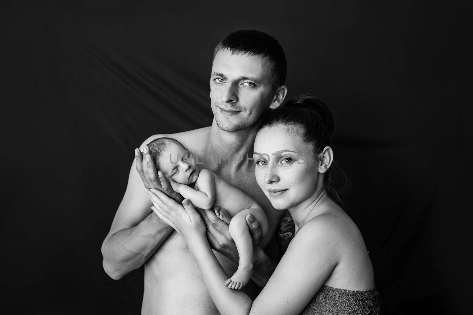 Mother and father holding their newborn baby at a newborn photoshoot. High quality photo