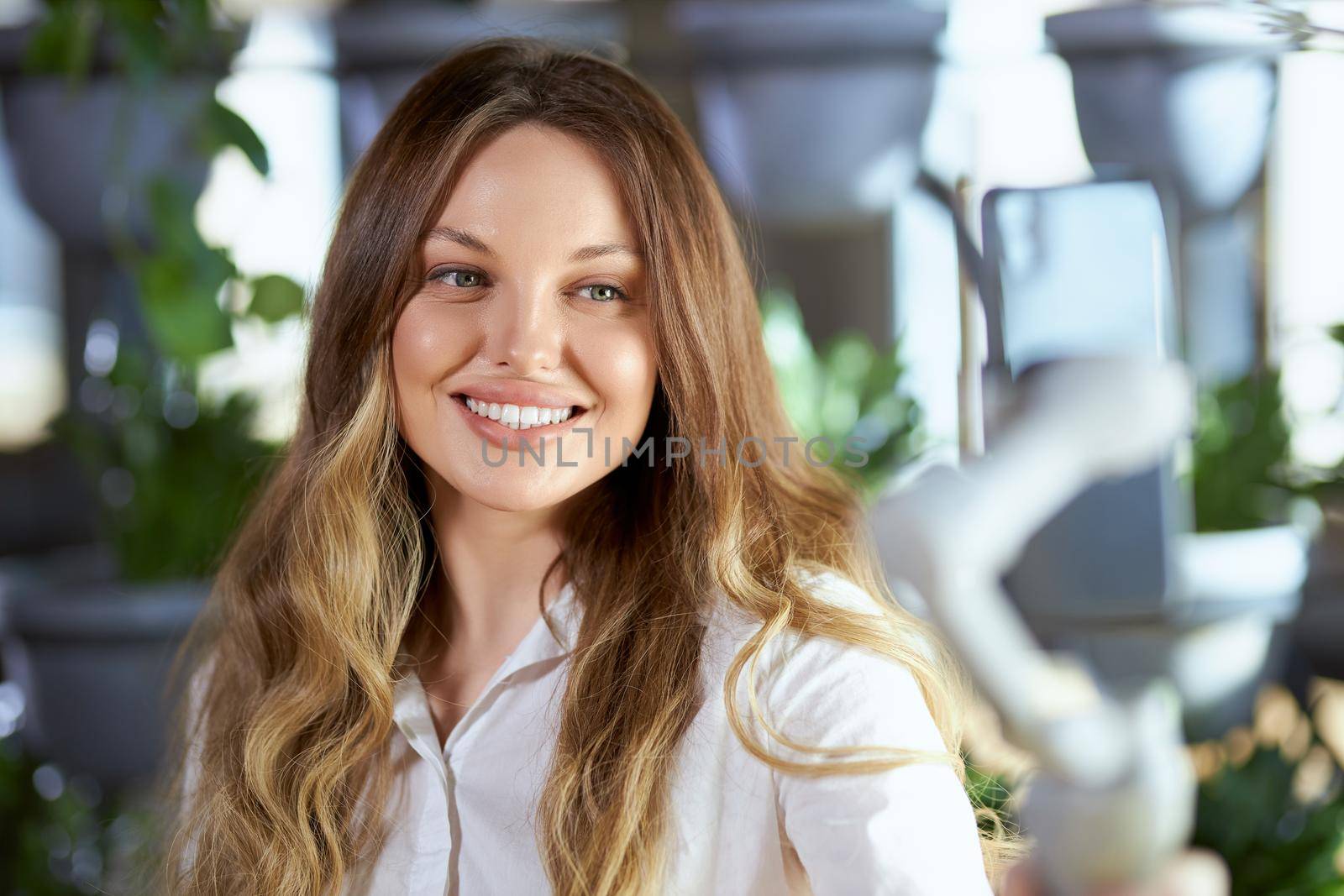 Close up portrait of happy beautiful young blogger woman talking with friends or followers on modern phone. Concept of communication online with interesting people in good mood. 