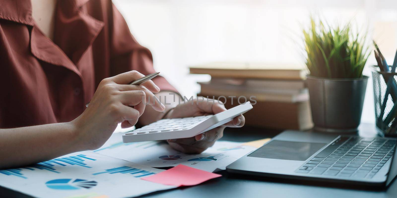 Business woman using calculator for do math finance on wooden desk in office, tax, accounting, statistics home accounring concept