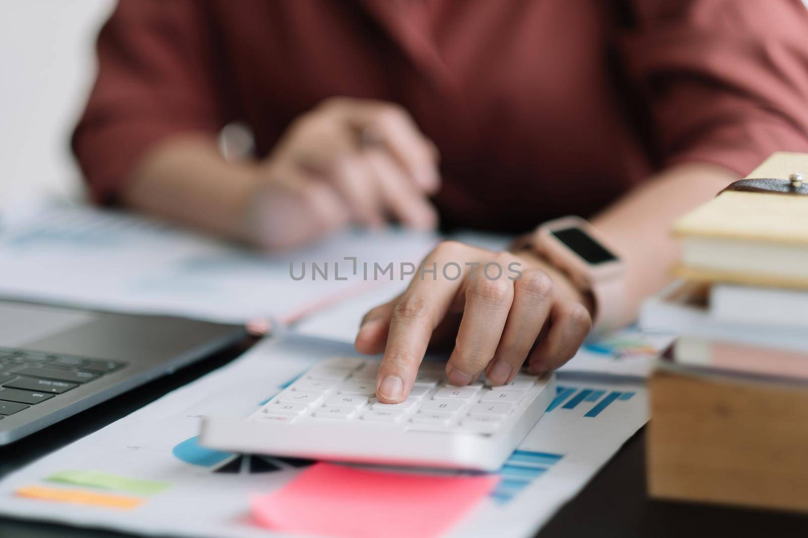 Business woman using calculator for do math finance on wooden desk in office, tax, accounting, statistics home accounring concept