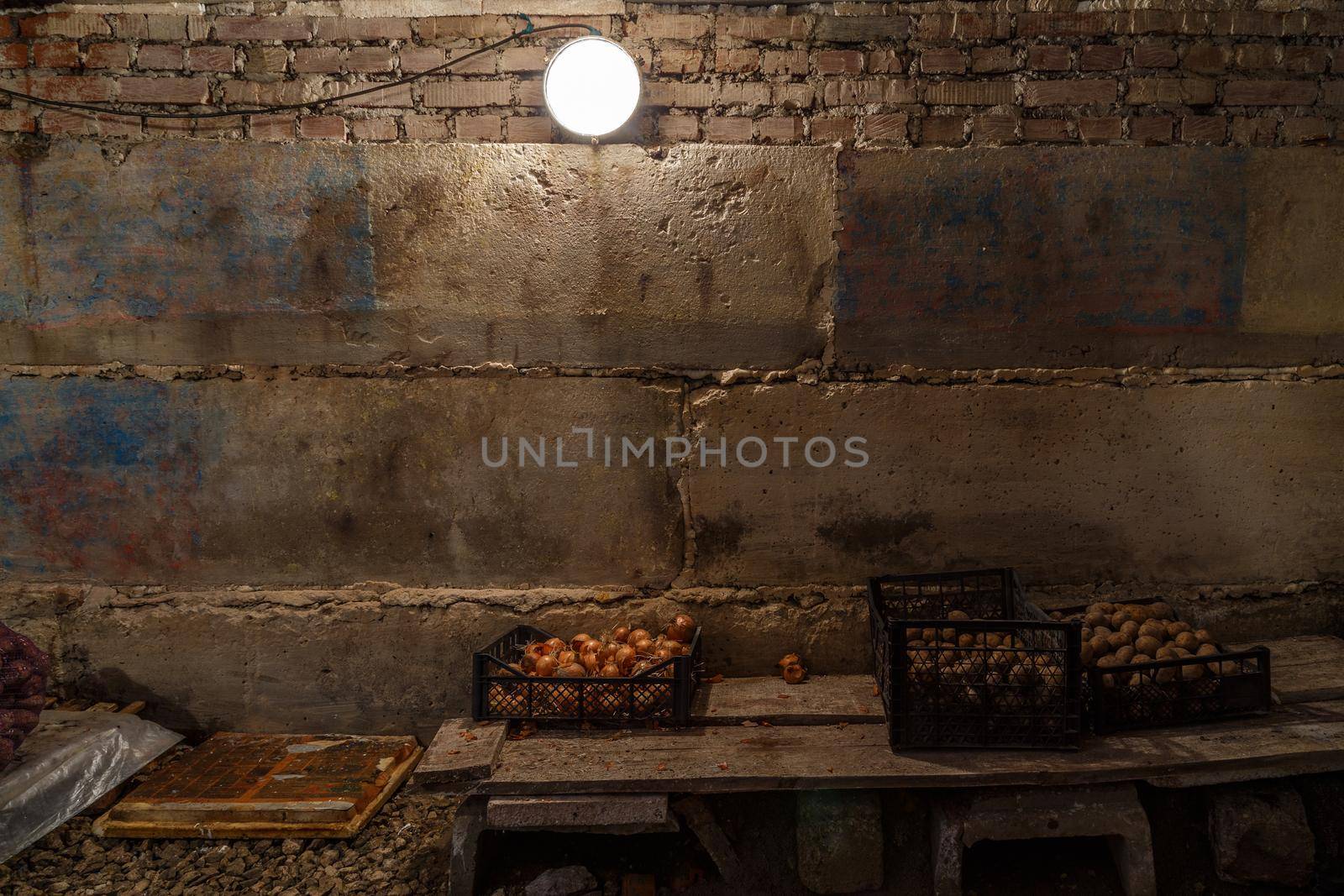 basement with few onion and potatoes storage in plastic boxes