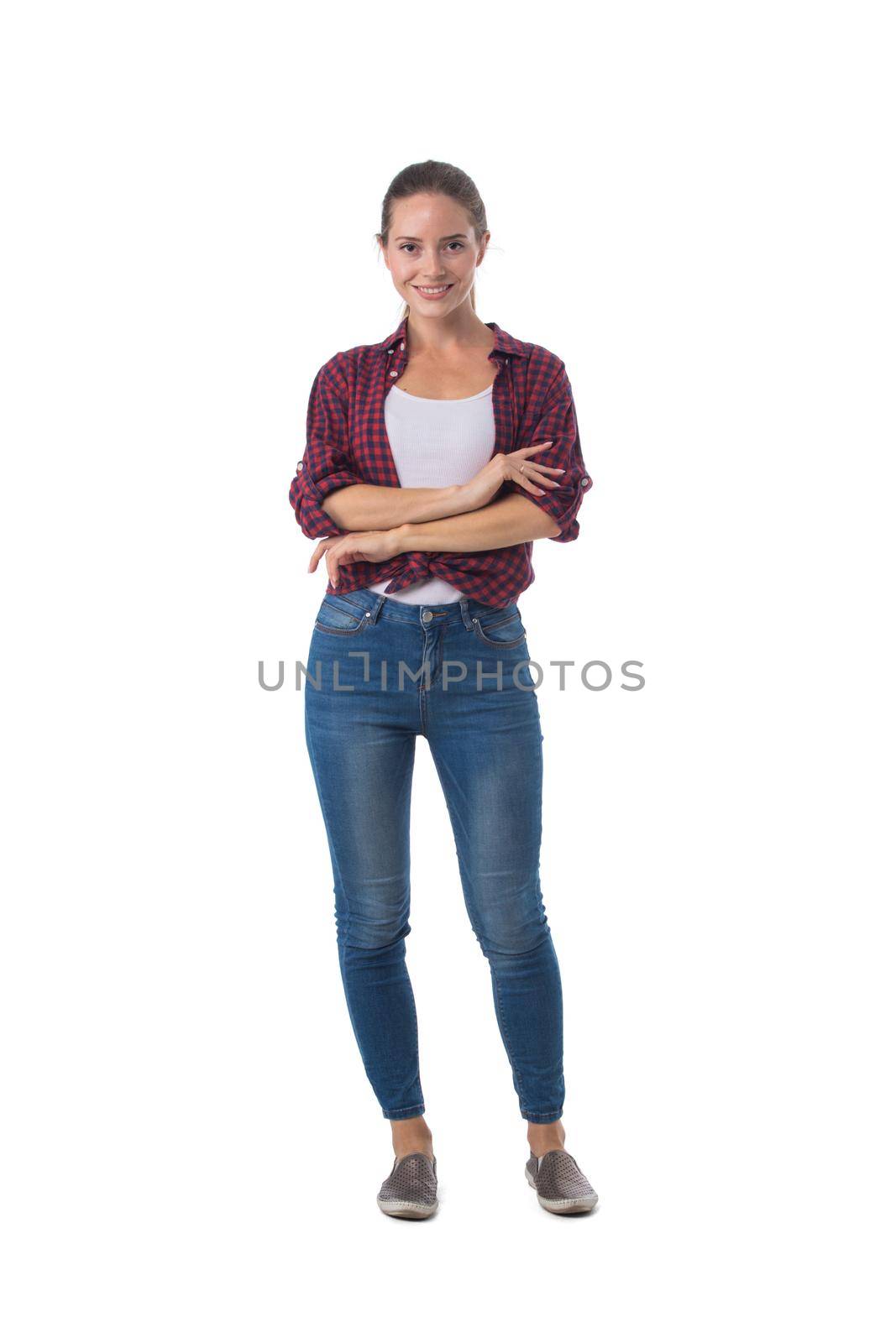 Full length portrait of smiling young woman with her arms folded isolated on white background, casual people