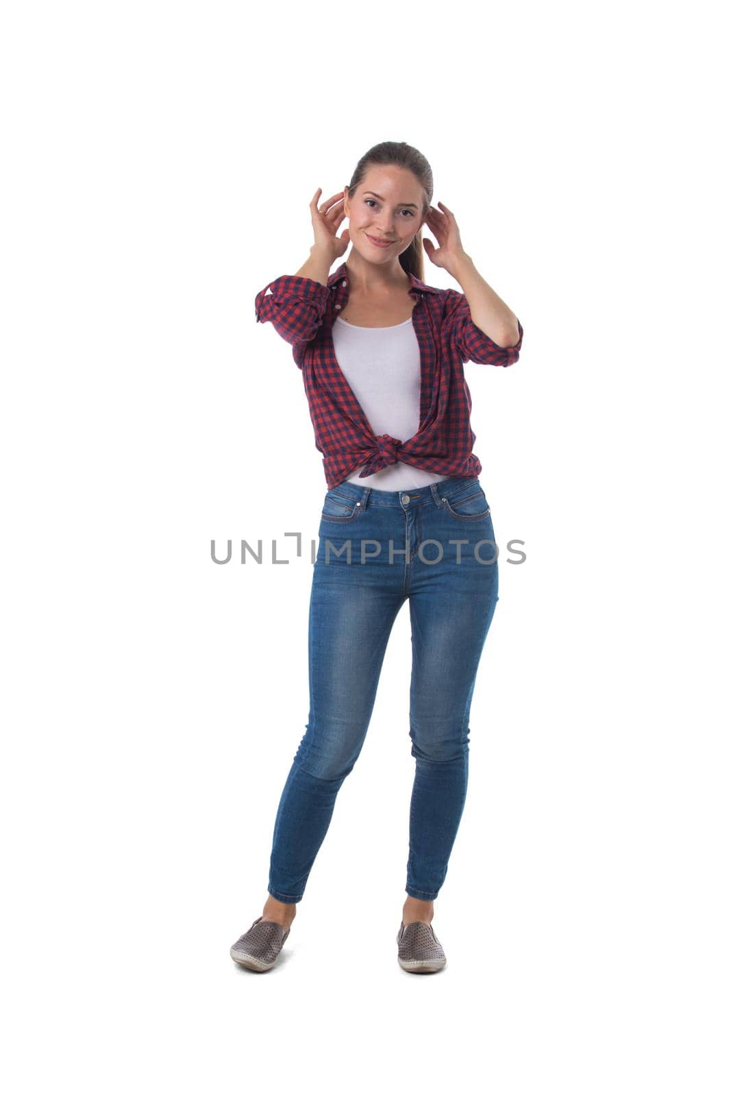 Full length portrait of smiling young woman in motion touching hair isolated on white background, casual people