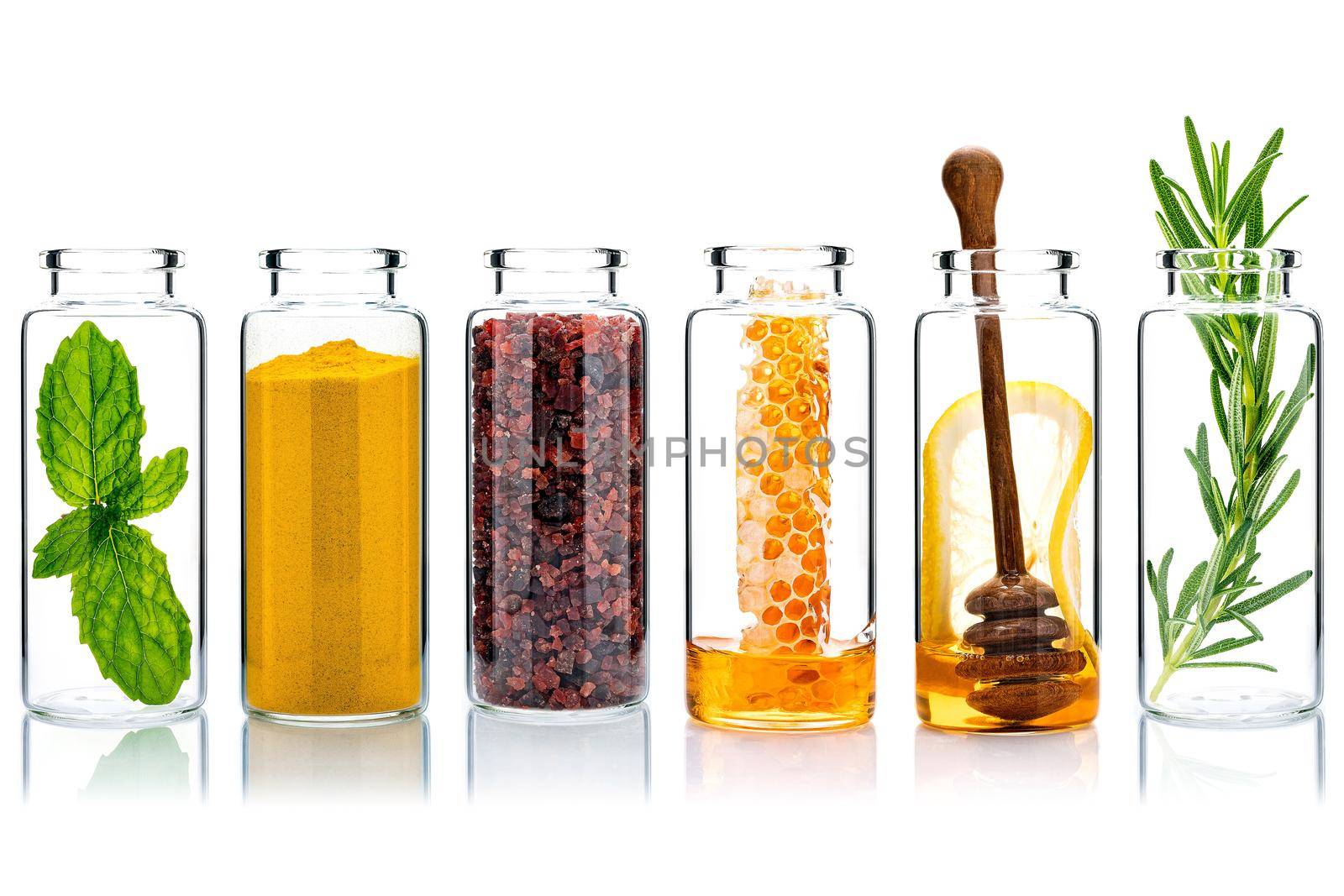 The glass bottle of homemade skin care and body scrubs with natural ingredients himalayan salt ,peppermint ,rosemary,turmeric and honey isolate on white background.