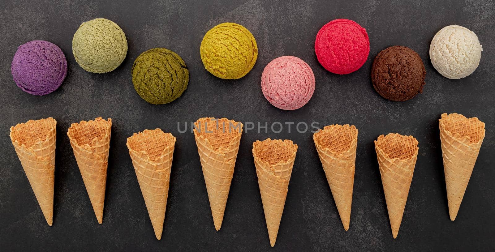 Various of ice cream flavor blueberry ,pistachio ,almond , orange, green tea and chocolate setup on dark stone background . Summer and Sweet menu concept.  by kerdkanno