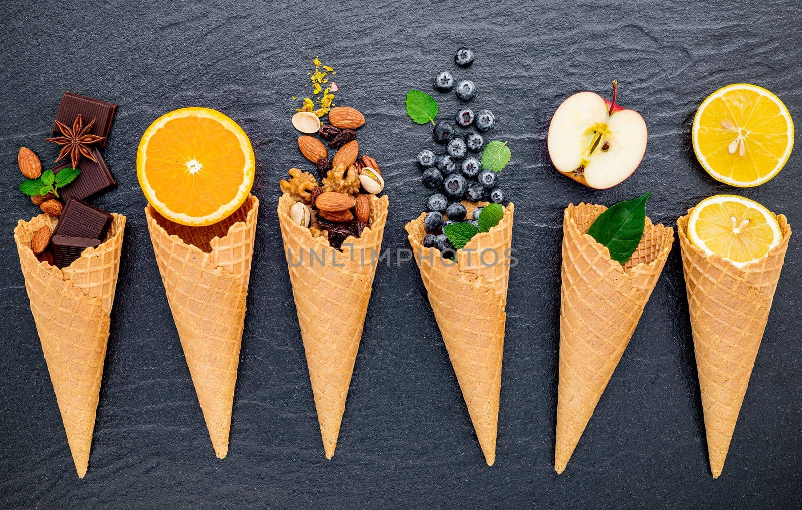 Various of ingredient for ice cream flavor in cones  set up on dark stone background .  by kerdkanno