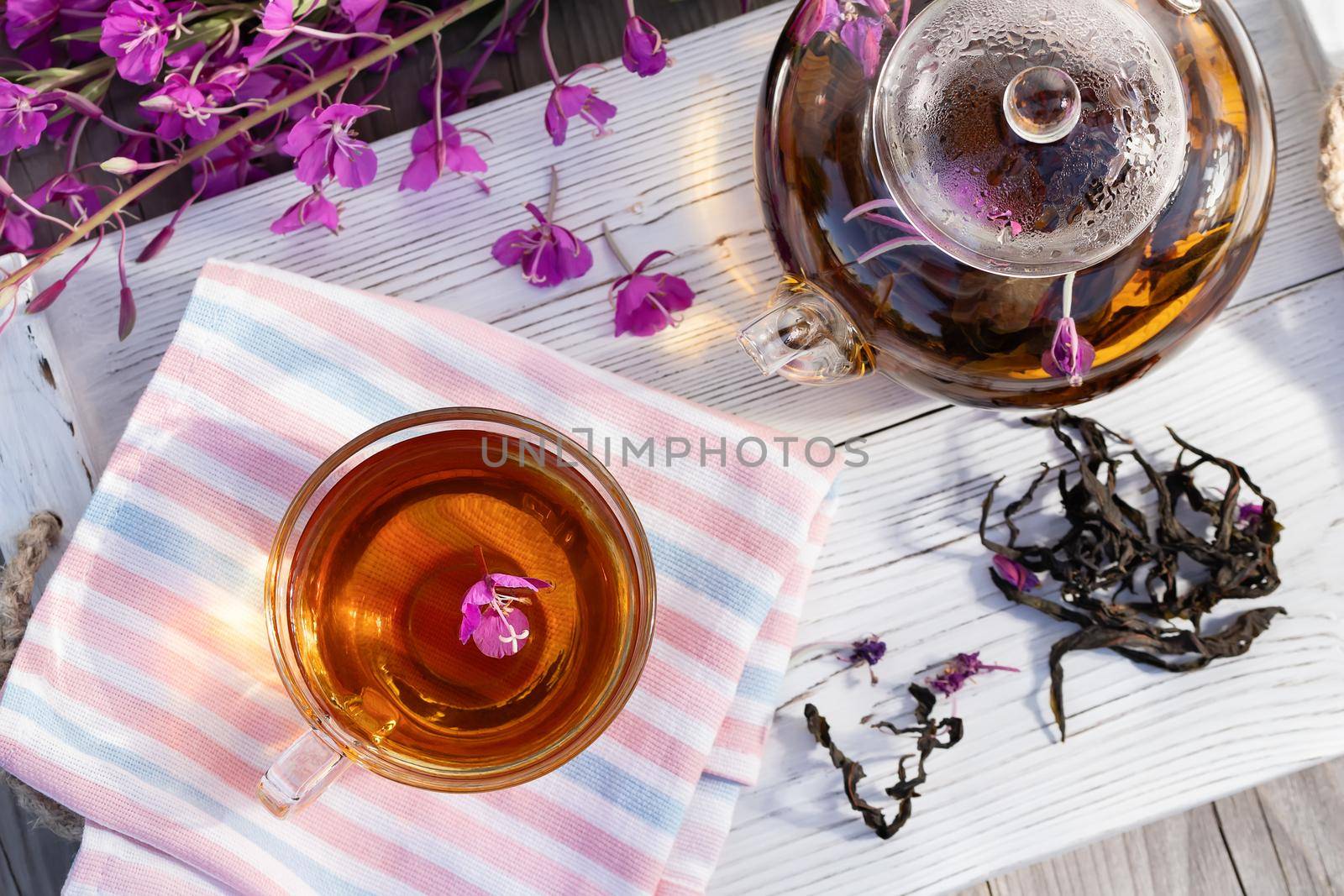 Herbal tea made from fireweed known as blooming sally in teapot and cup, top view.