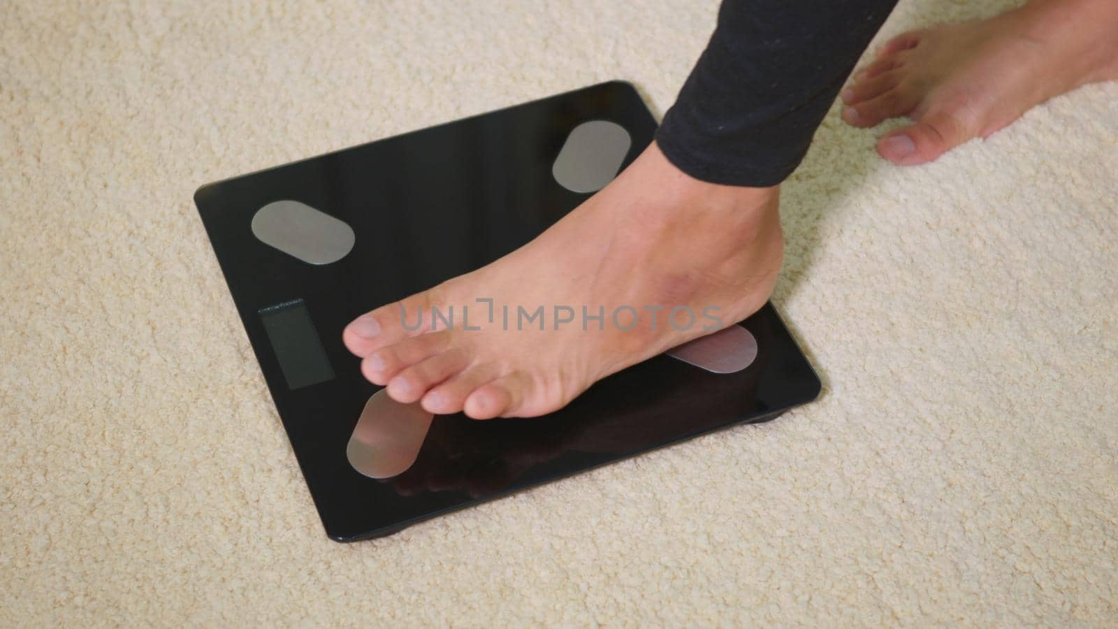Asian young woman leg stepping standing on floor electric scales, female working out at home in living room, female stand on digital weighing machine. Healthy weight loss control concept, slow motion