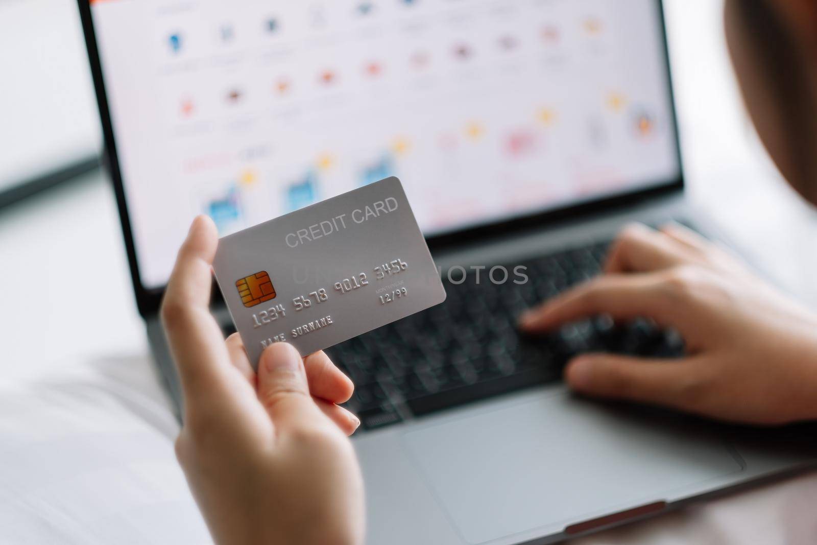 woman shopping online with credit card. woman holding credit card and using laptop. Online shopping concept by nateemee