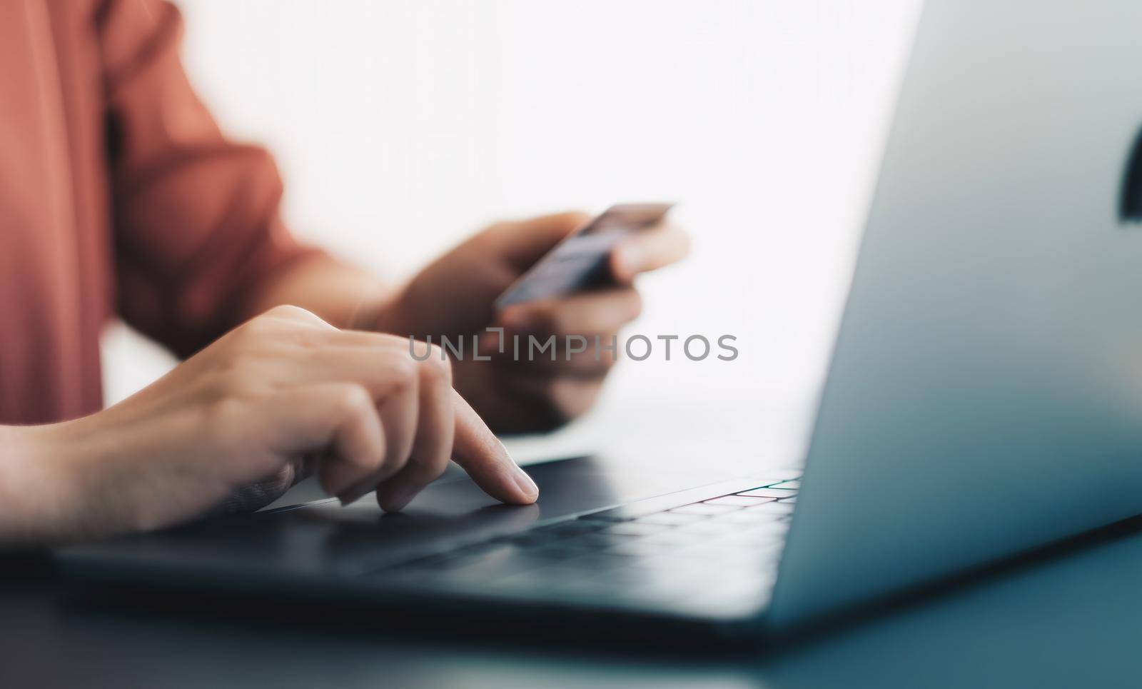 Hands holding plastic credit card and using laptop. Online shopping concept. soft focus by nateemee