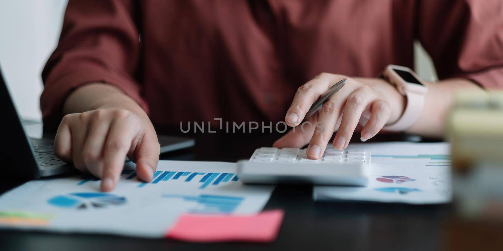 accountant working on desk using calculator for calculate finance report in office by nateemee