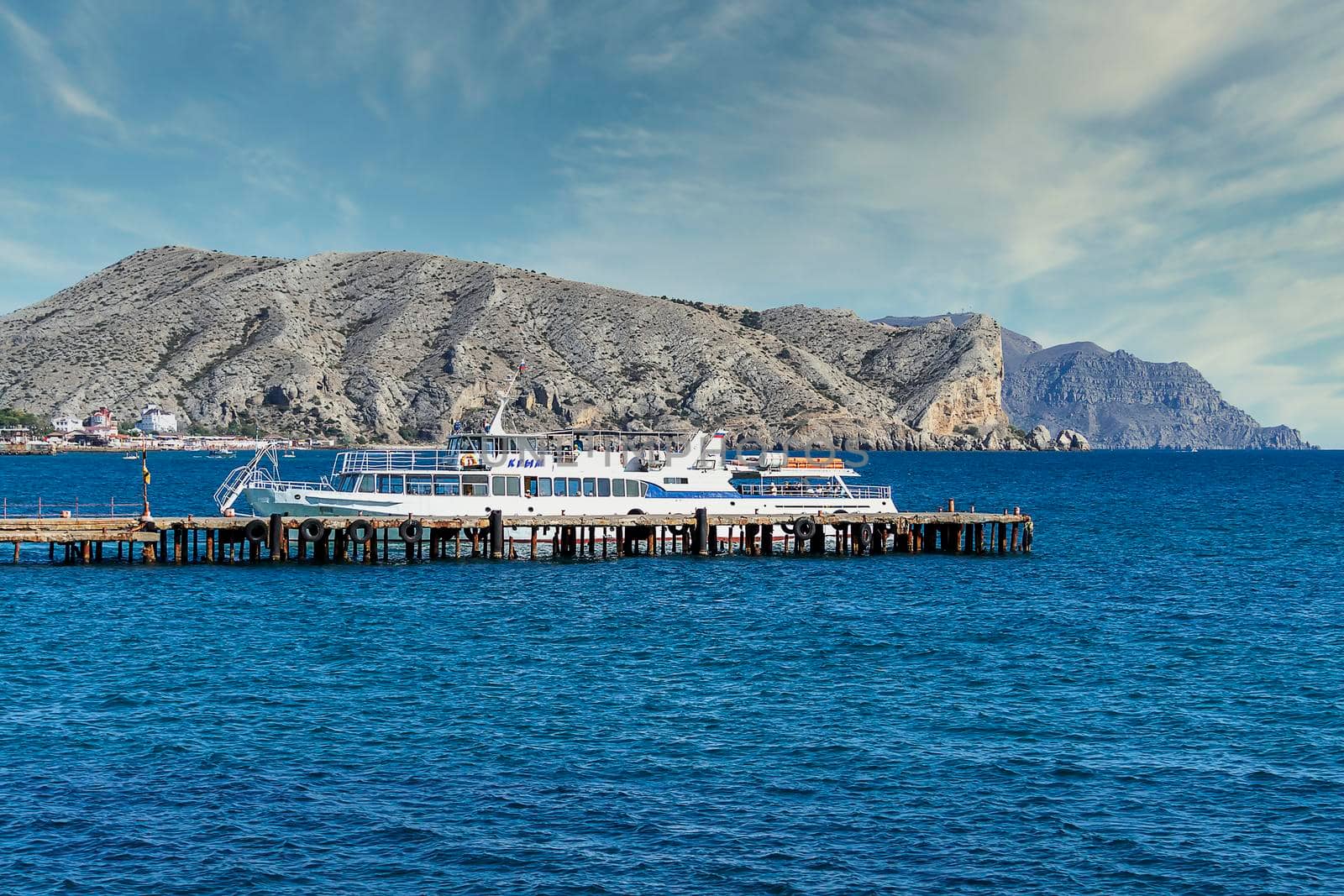 Black sea and boat, pier. View of Mount Alchak. Crimea, Sudak - 10 October 2020. by Essffes