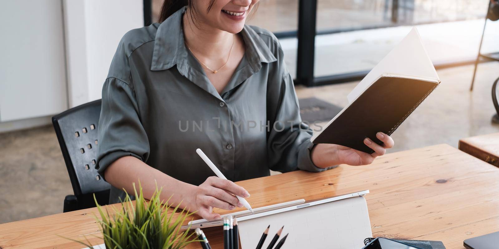Asian Business woman working with tablet in home office. Work from home concept. by itchaznong