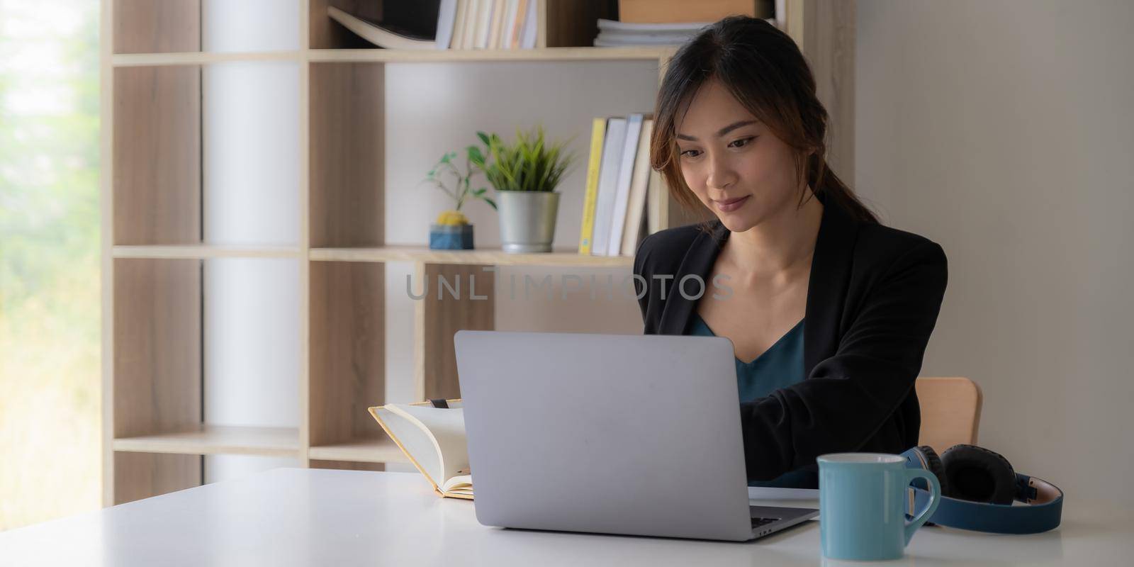 Work from home concept, Asian business woman using laptop, communicates on internet with customer in home