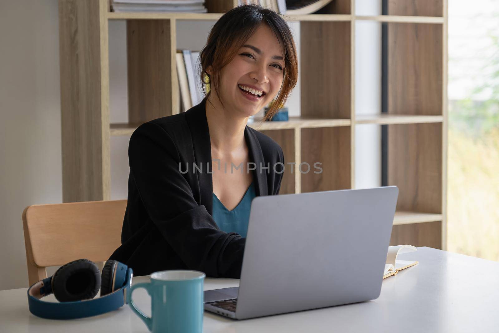 Work from home concept, Asian business woman using laptop, communicates on internet with customer in home