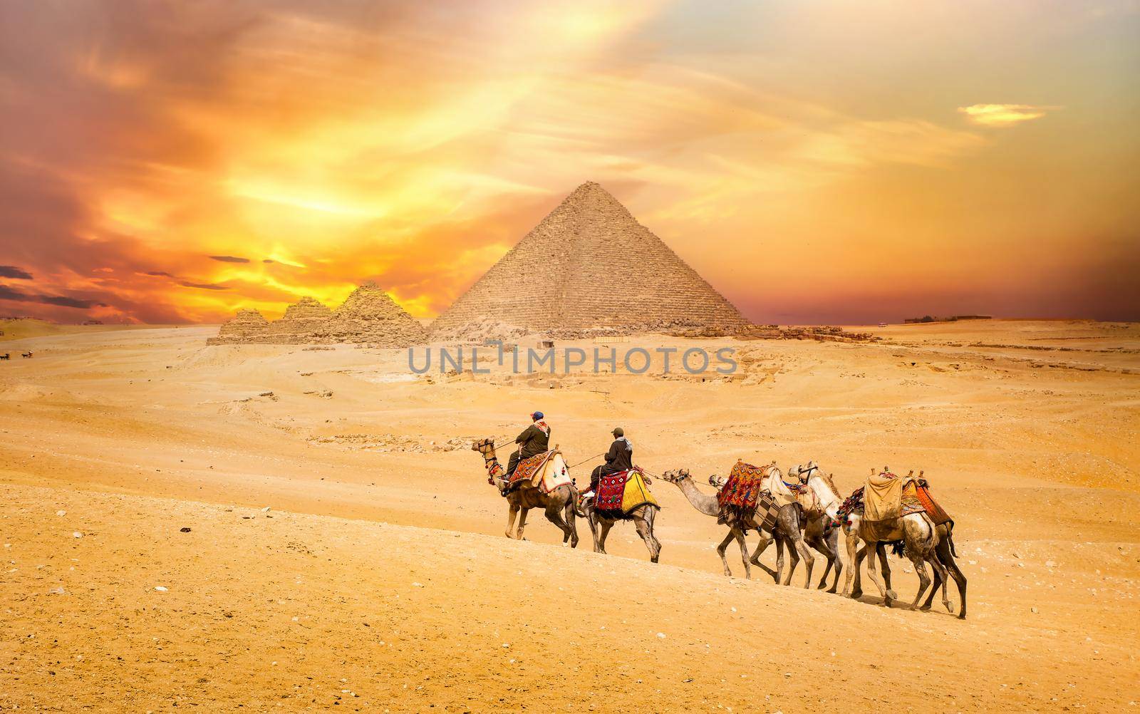 Egyptian pyramids in the desert at sunset