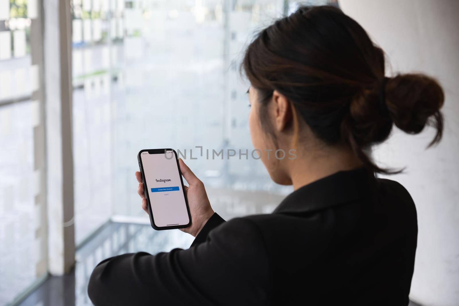 CHIANG MAI, THAILAND - MAR 01, 2021: A woman hand holding iphone with login screen of instagram application. Instagram is largest and most popular photograph social networking