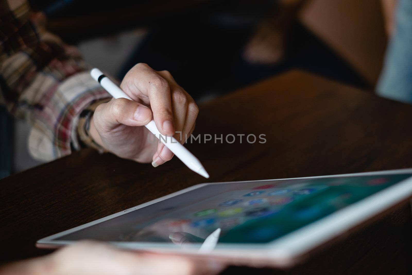CHIANG MAI, THAILAND - FEB 26, 2020 : Hand of woman using Ipad and pencil with icons of social media on screen, smartphone life style, smartphone era, smartphone in everyday life by itchaznong