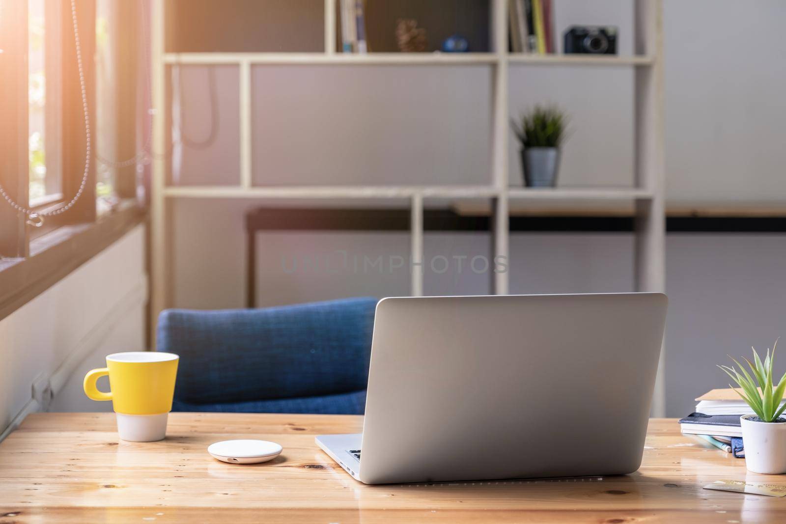 Laptop computer mockup on wooden table with morning light