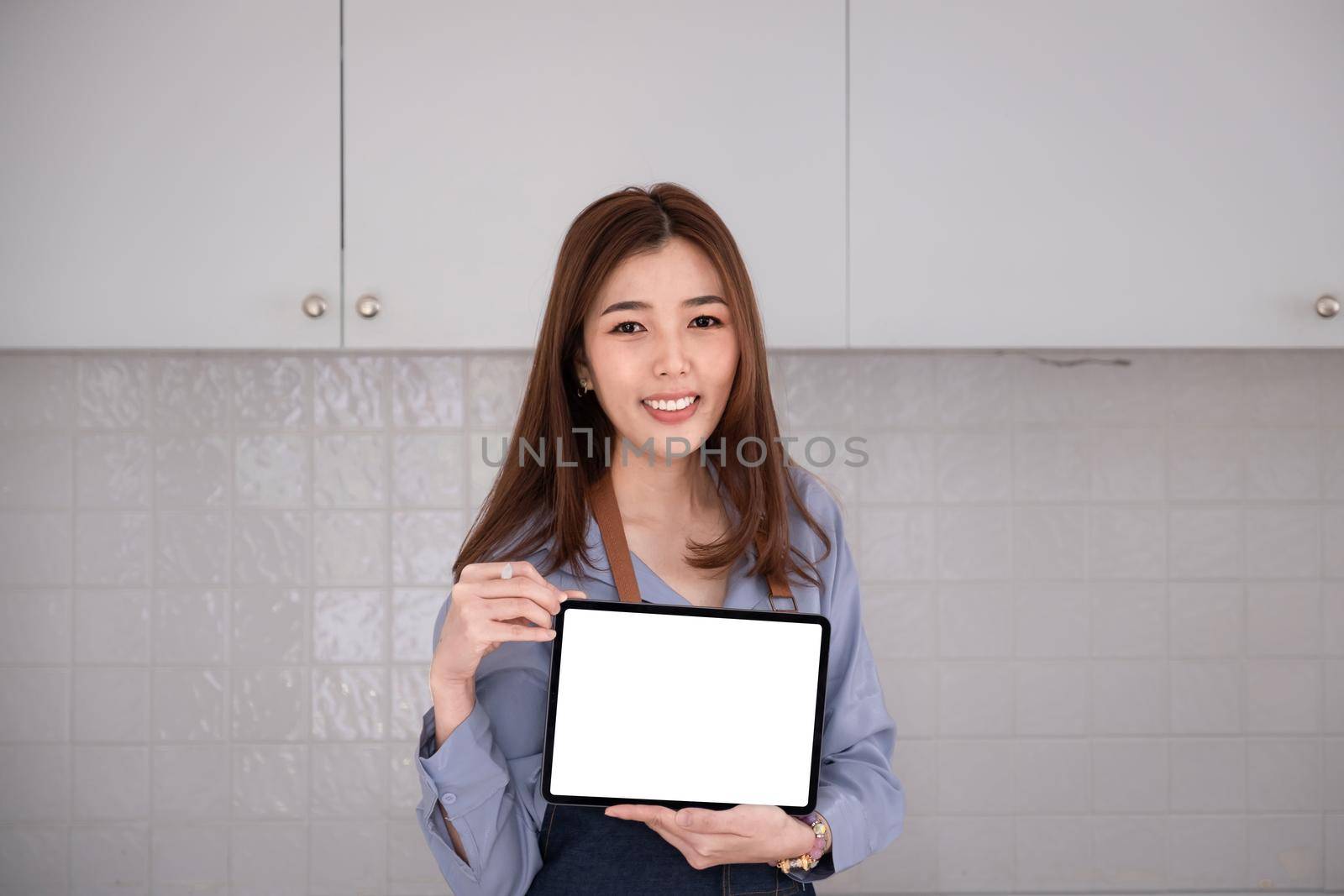 Businesswoman holding tablet blank screen with smile. by itchaznong