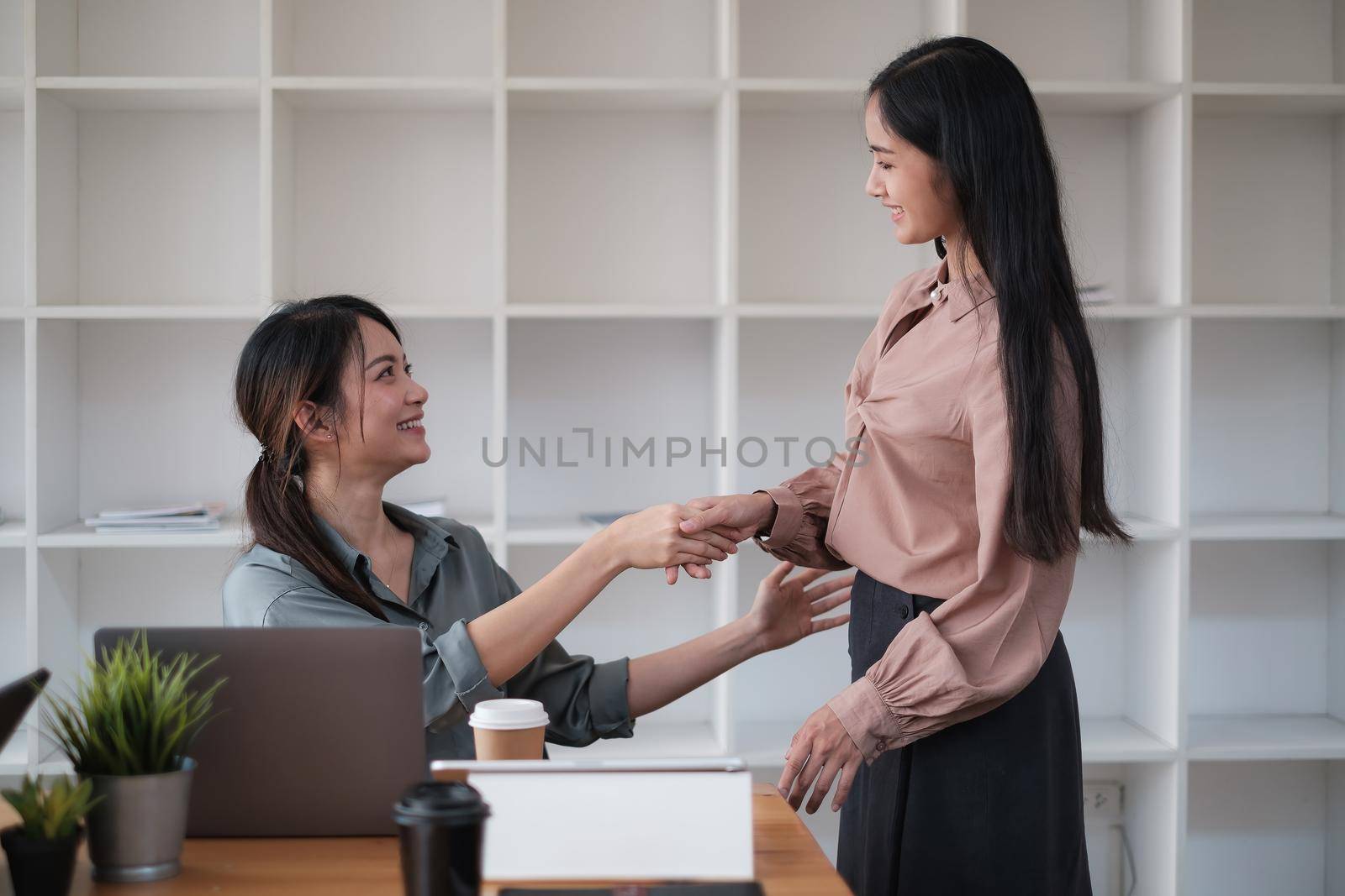 Business partnership meeting concept. Image business womans handshake. Successful business handshaking after good deal. Group support concept. by itchaznong