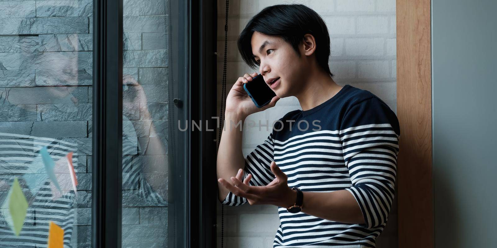 Portrait of businessman discussing to his partners about new product while talking with mobile phone in home office