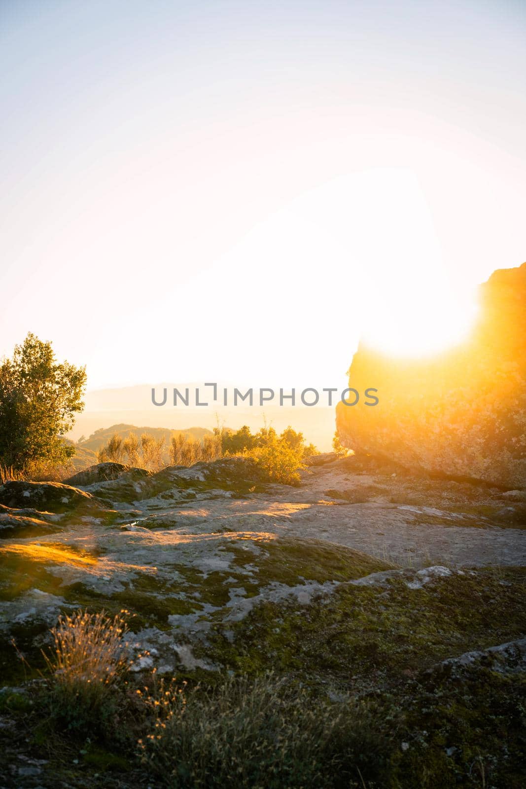 Sortelha nature mountain landscape with sun flare on a boulder, in Portugal by Luispinaphotography