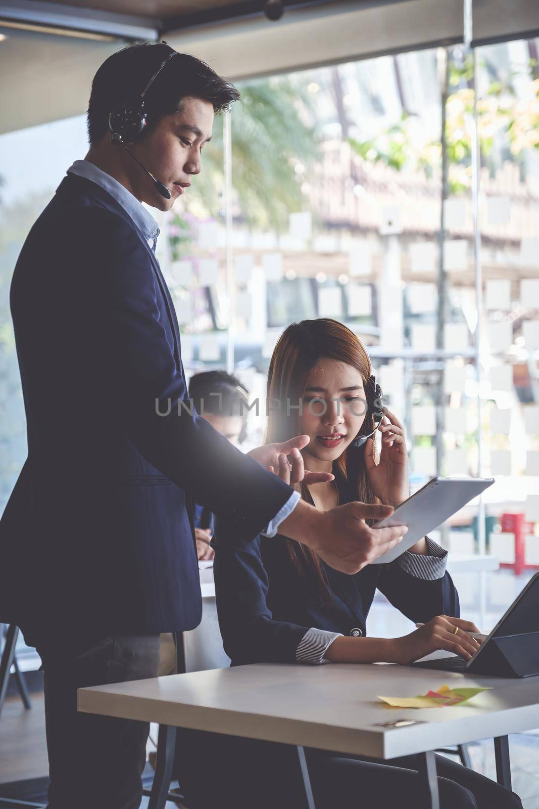 Female operator discussing with her team before communicates with the client