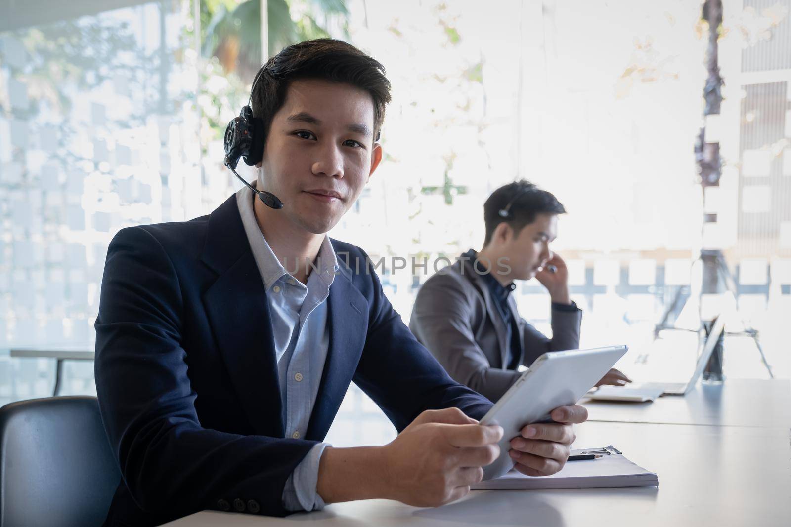 Customer support operator team with hands-free headset working in the office. by itchaznong