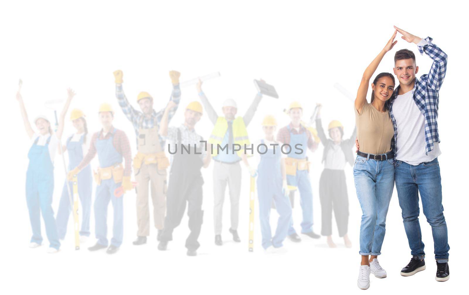 Happy young couple holding hand over the head showing house roof sign and happy construction workers on background isolated on white background