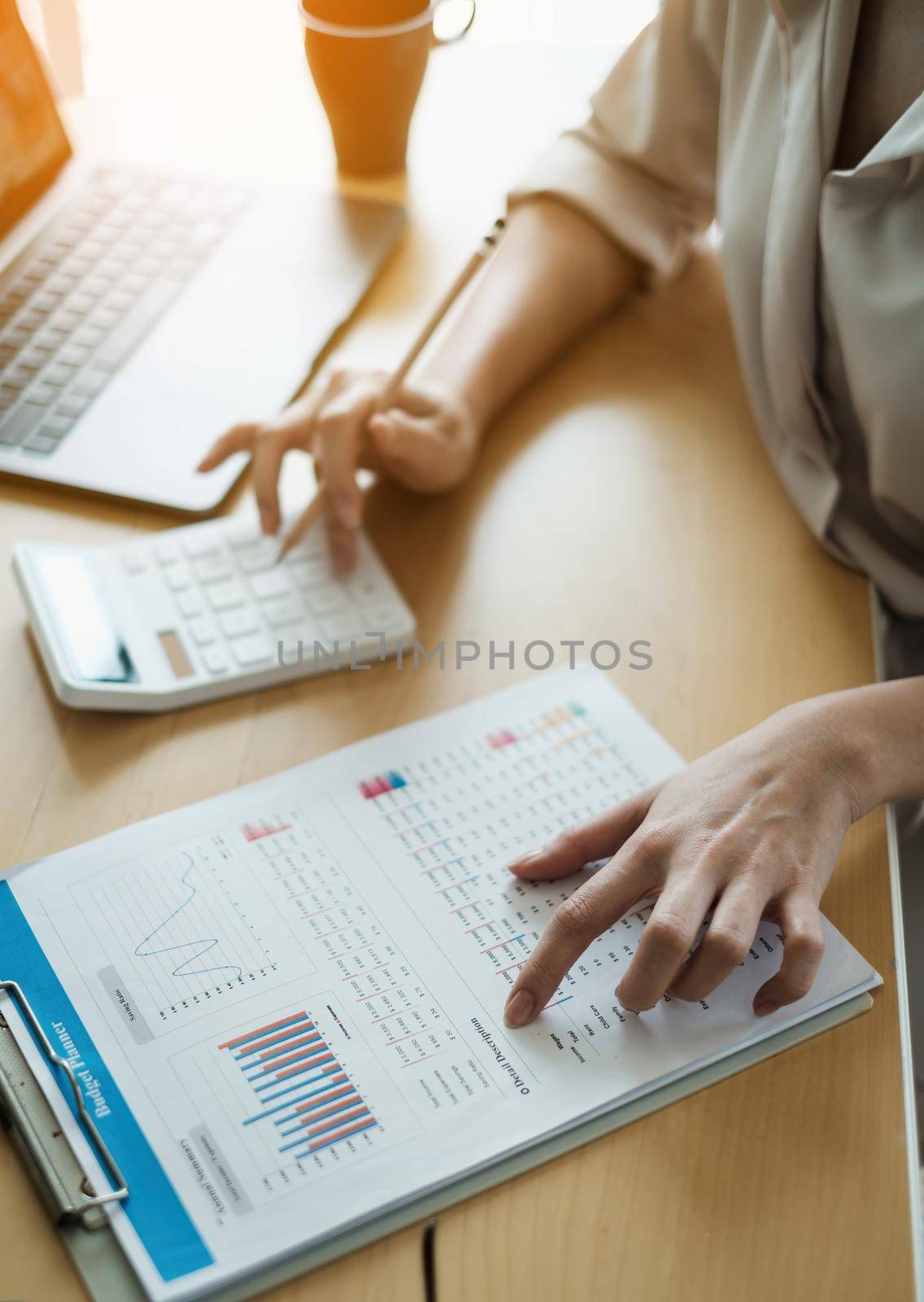 Business woman using a calculator to calculate working on desk in home office. Consultant,Financial Consultant,Financial advisor and accounting concept. by itchaznong