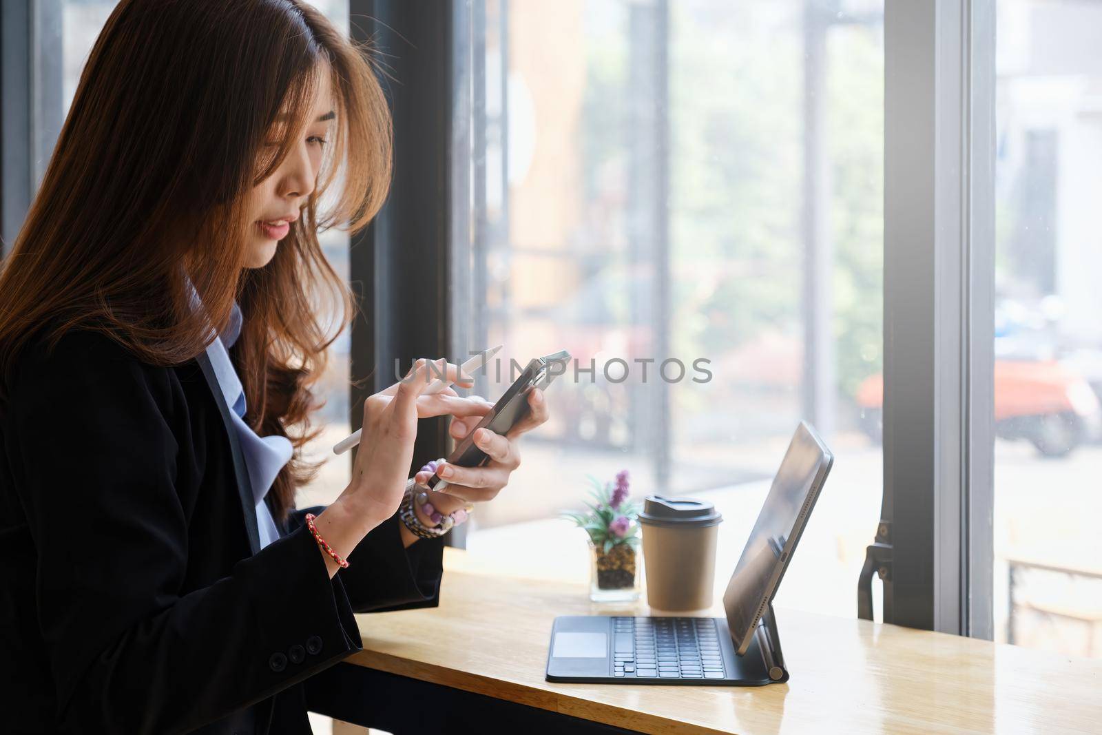 Closeup of Woman with a finger on the screen using a mobile phone in the office. Business woman hand using mobile smart phone and reading message via application