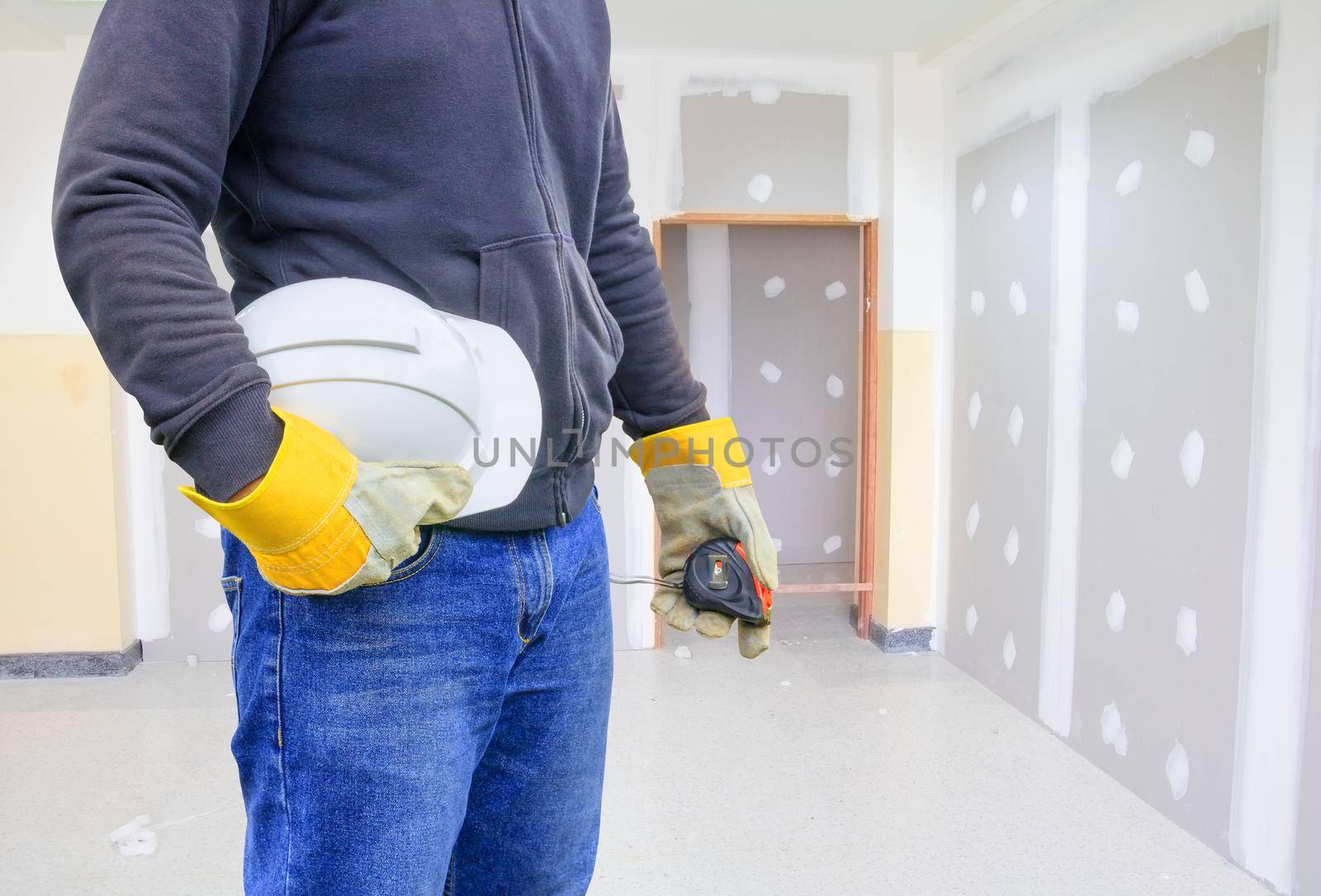 engineering hand holding white safety hat working interior gypsum renovate house  construction site in building with copy space add text by pramot