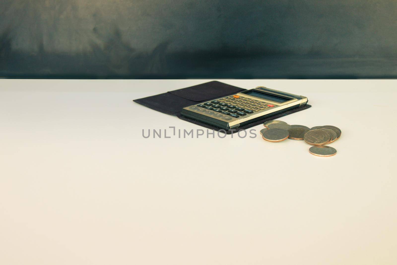 coin money and calculator old, book over white and black background with copy space add text. color vintage style tone by pramot