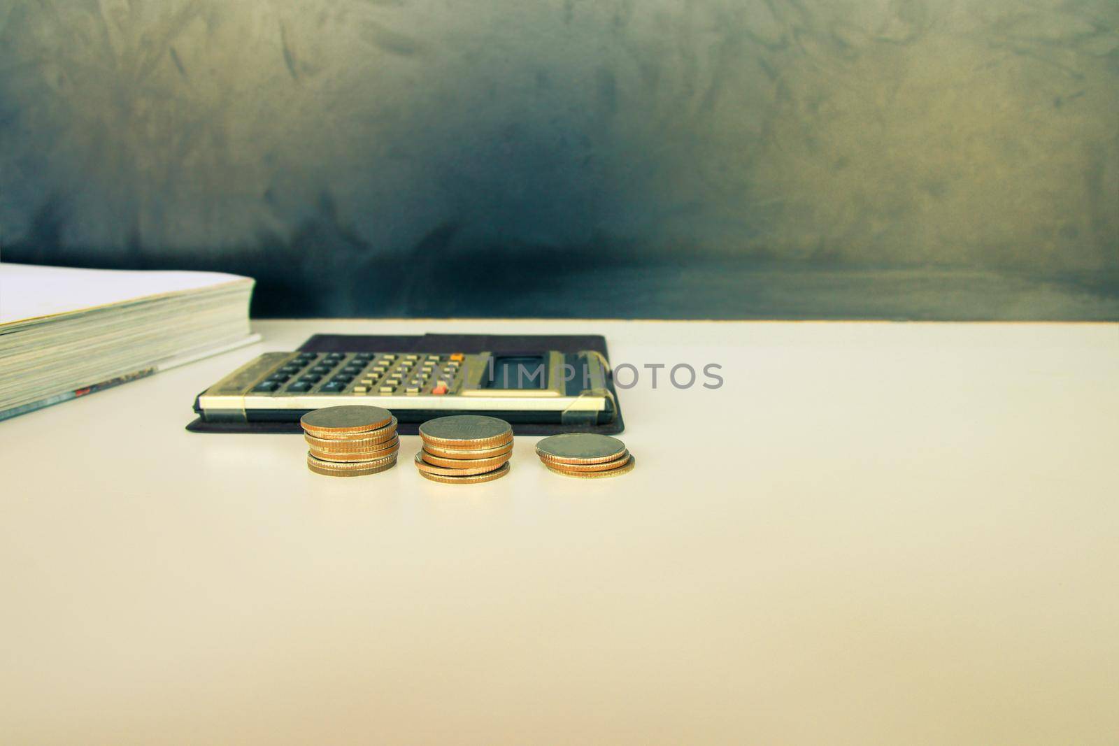 coin money and calculator old, book over white and black background with copy space add text. color vintage style tone