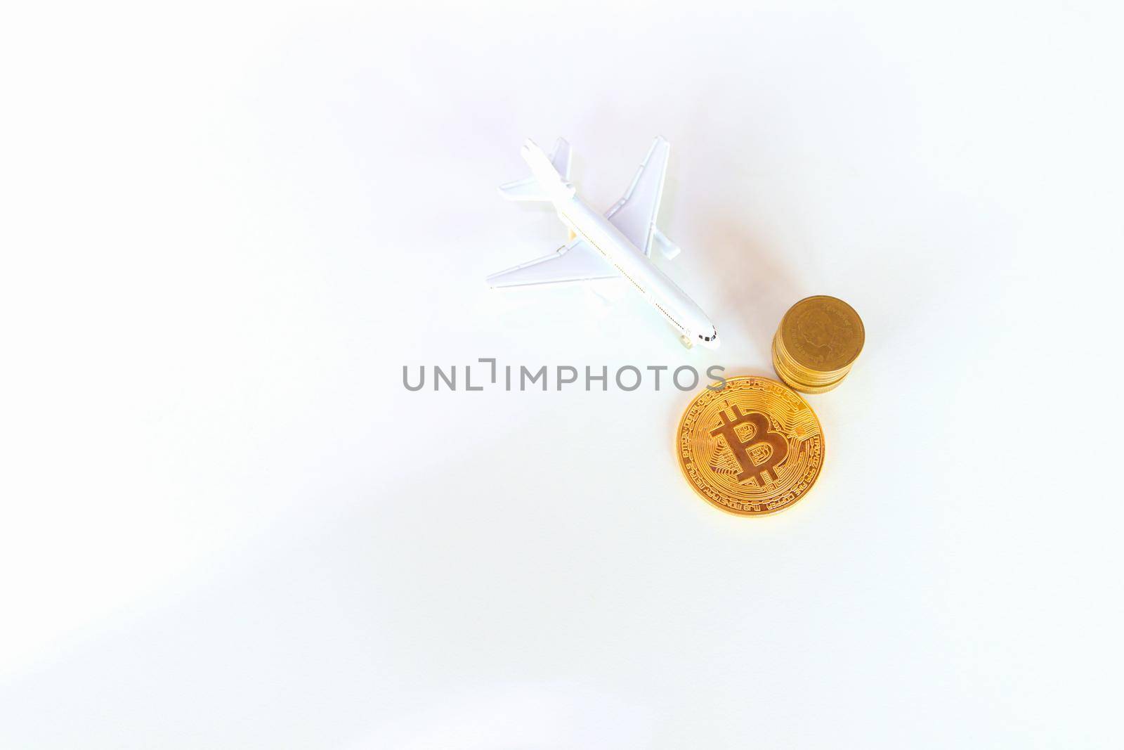 bitcoin coins and  and model of passenger plane  over white on black background. with copy space add text Top view
