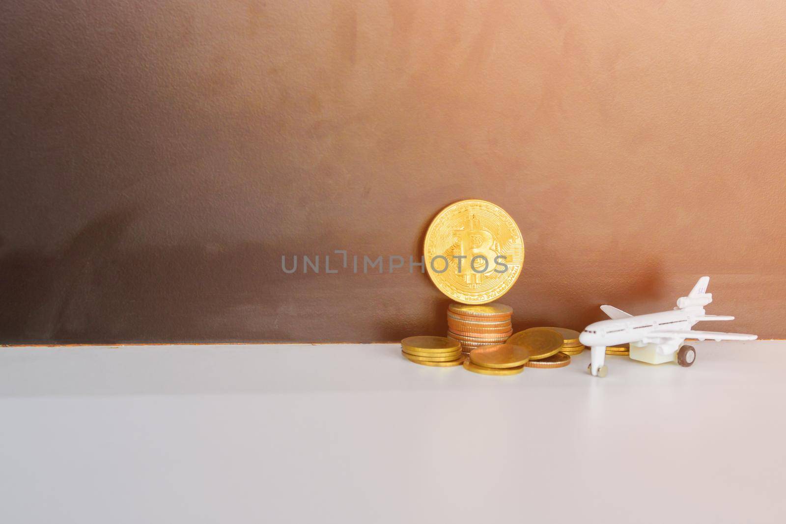 bitcoin coins and money stack and model of passenger plane  over white on black background. with copy space add text