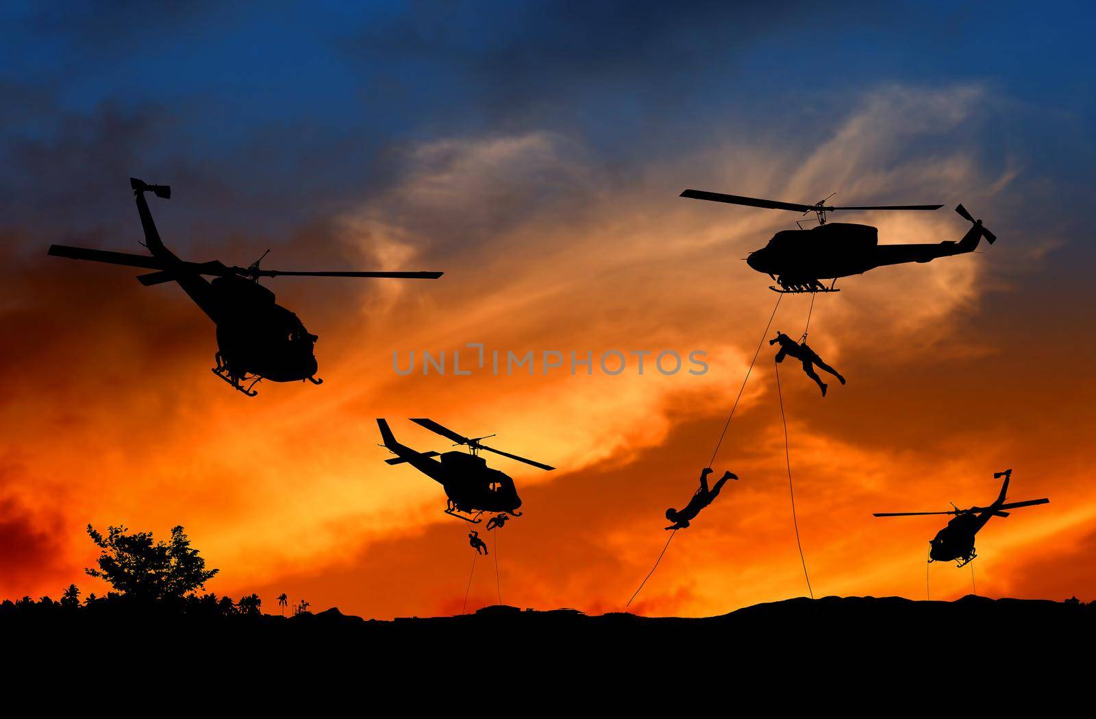 Silhouette Soldiers rappel down to attack from helicopter with sunset and copy space add text ( Concept stop hostilities To peace) by pramot