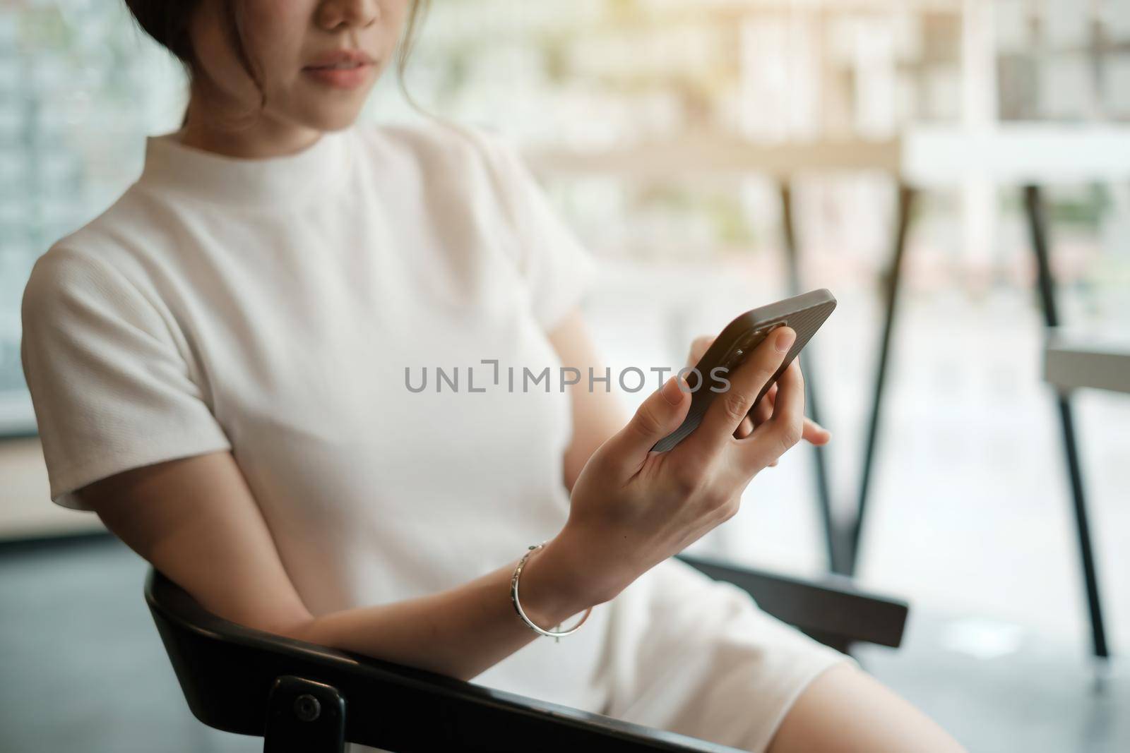 Close up of hand holding, using cell phone for invite her friend meeting at cafe when open after covid-19 have vaccine