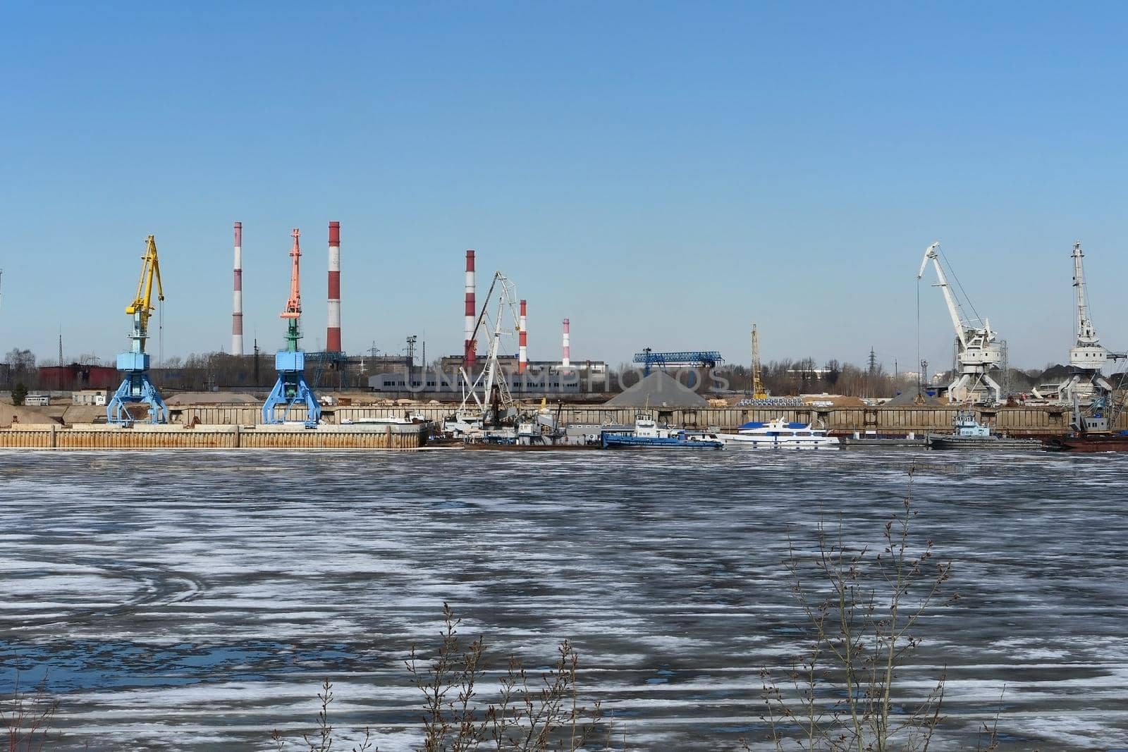 Spring ice on the river. Plant by the river and sand mining. High quality photo