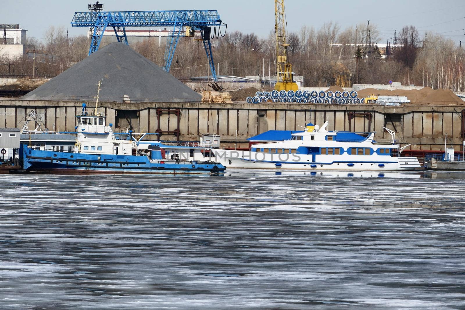 River port. The factory by the river. Sand mining. A crane and special equipment for loading sand. High quality photo